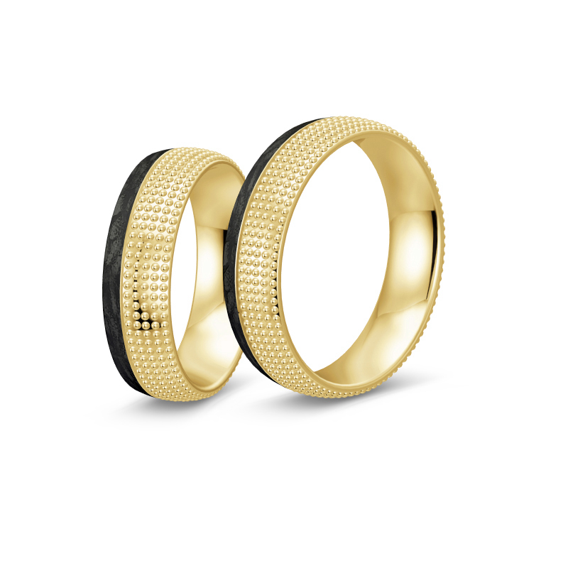 Aufnahme von taktilen Eheringe aus Gelbgold und Carbon mit Diamanten und Kreismuster