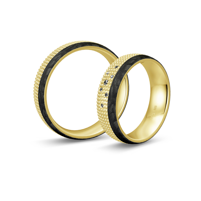 Aufnahme von taktilen Eheringe aus Gelbgold und Carbon mit Diamanten und Kreismuster 