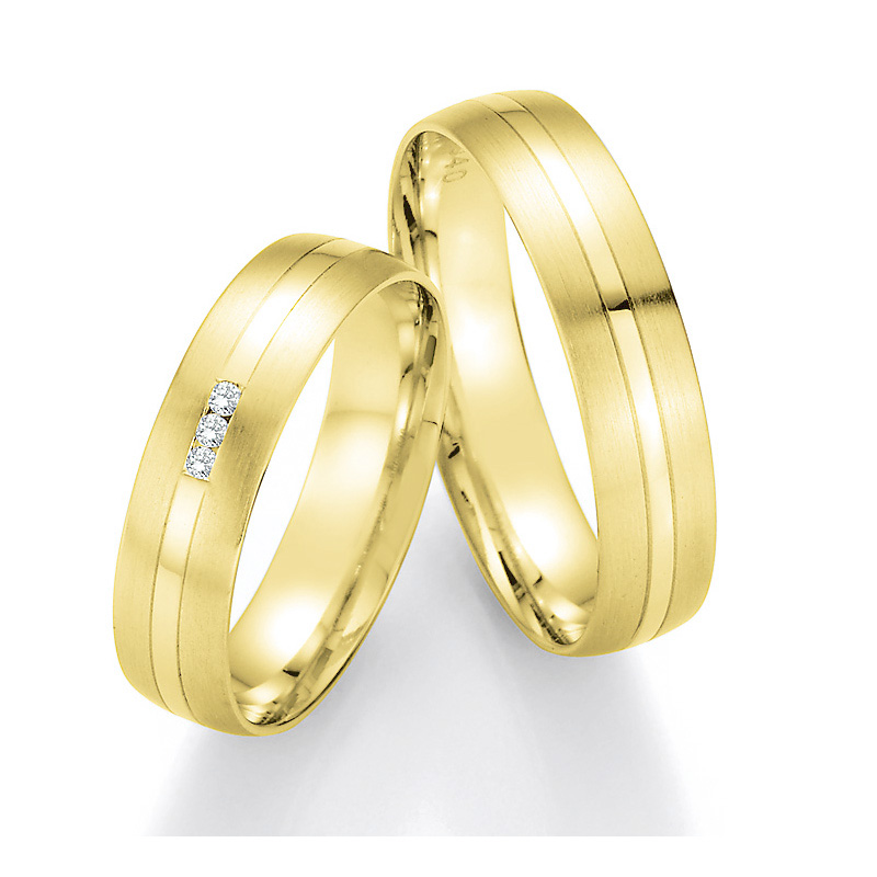 Aufnahme von Eheringe aus Gelbgold mit 3 Diamanten mit matten Rändern und Polierung 