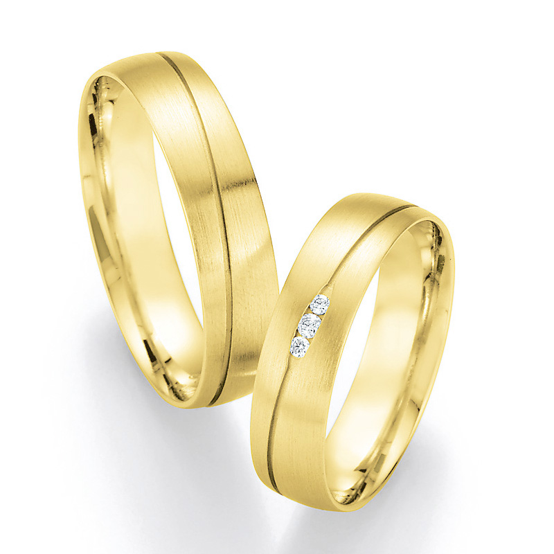 Aufnahme von längsmattierten Eheringen aus Gelbgold mit ovaler Rille und Diamanten