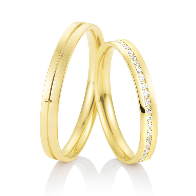 Aufnahme von schmalen Eheringe aus Gelbgold mit Diamanten und prominenter RIlle