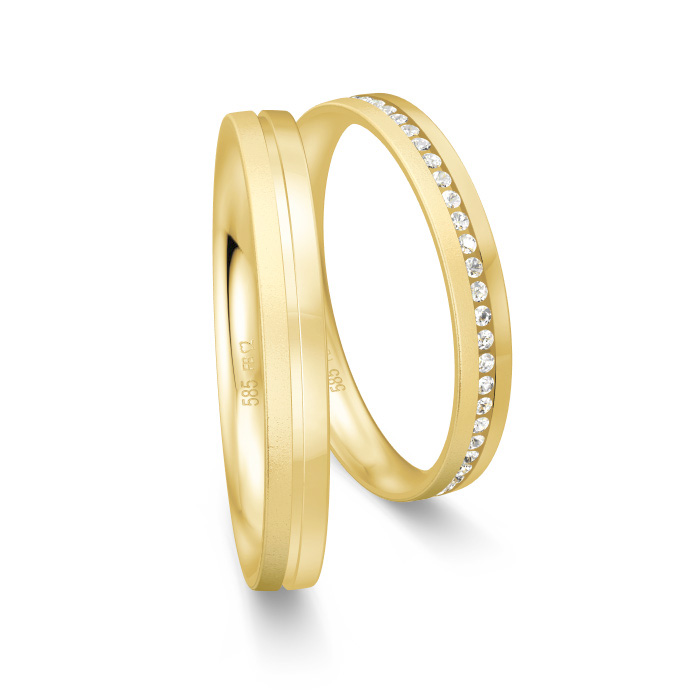 Aufnahme von schmalen Eheringe aus Gelbgold mit Diamanten und prominenter RIlle