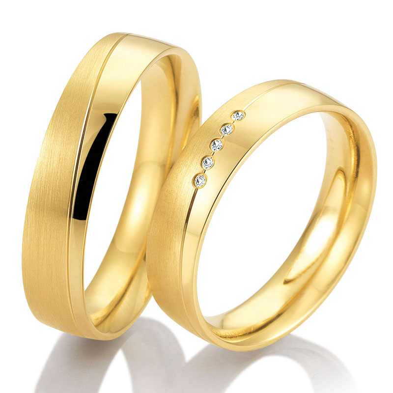  	Seitliche Aufnahme von Trauringen aus Gelbgold mit 5 Diamanten Polierung und Mattierung und Rillen