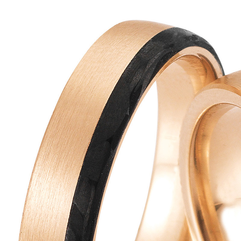 Aufnahme von längsmatten Eheringen aus Rosegold mit Carbonstreifen und Diamanten