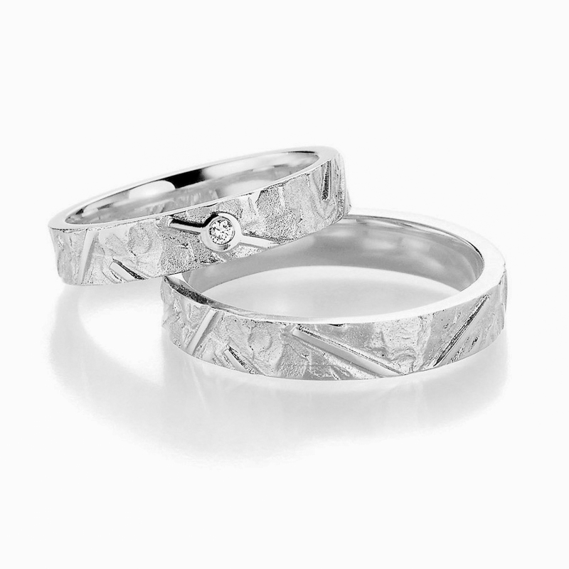 Aufnahme von gemusterten Silber Trauringen mit Diamanten und Strukturierung