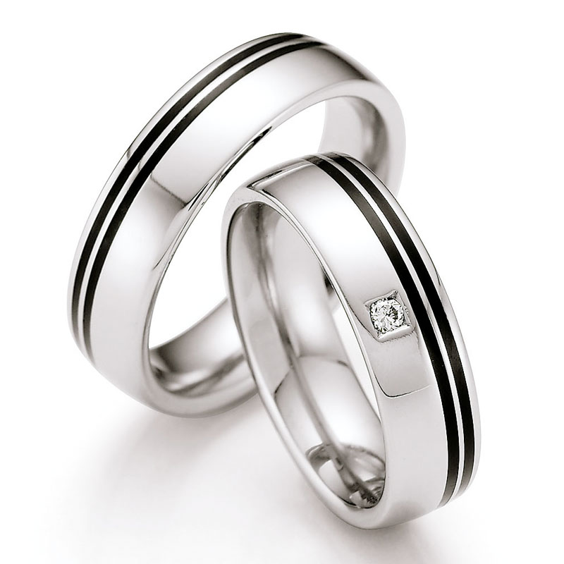 Frontale Aufnahme von Eheringen aus Edelstahl mit zwei schwarzen Keramikstreifen und Diamant 
