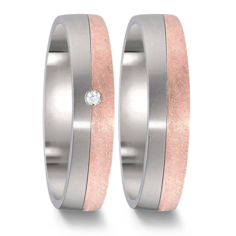 Frontale Aufnahme von Titan und Roségold Eheringen mit polierter und kratzmatter Flächen Diamanten