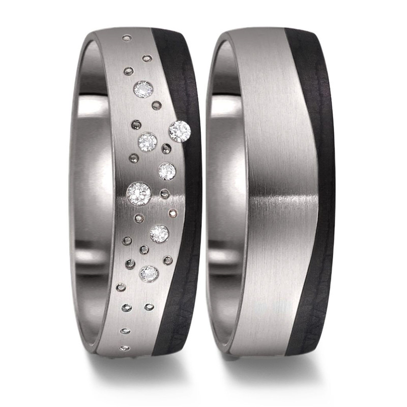 Aufnahme von bicoloren Eheringe aus Titan und Carbon mit vielen Diamanten und Kreismuster 