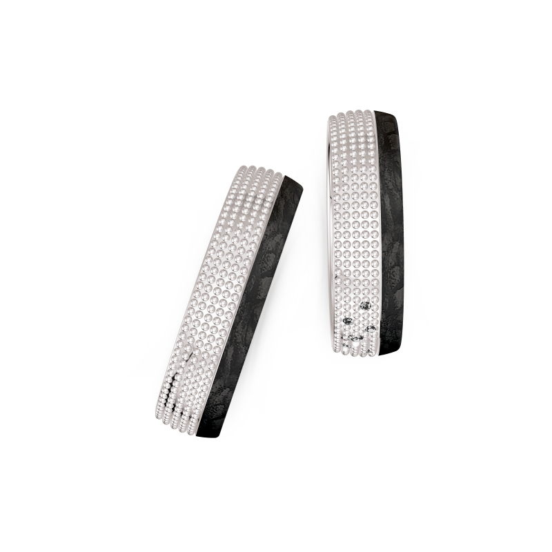 Aufnahme von taktilen Eheringe aus Weißgold und Carbon mit Diamanten und Kreismuster