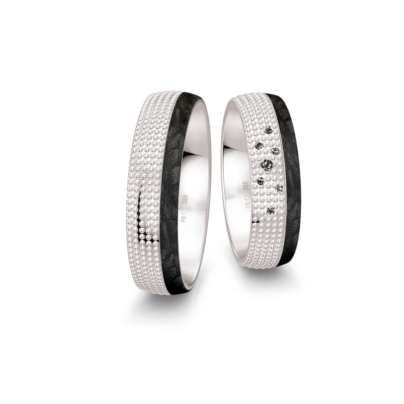 Aufnahme von taktilen Eheringe aus Weißgold und Carbon mit Diamanten und Kreismuster