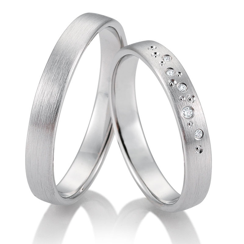  	Aufnahme von matten Trauringen aus Weissgold mit vielen Diamanten als Sternenhimmel 