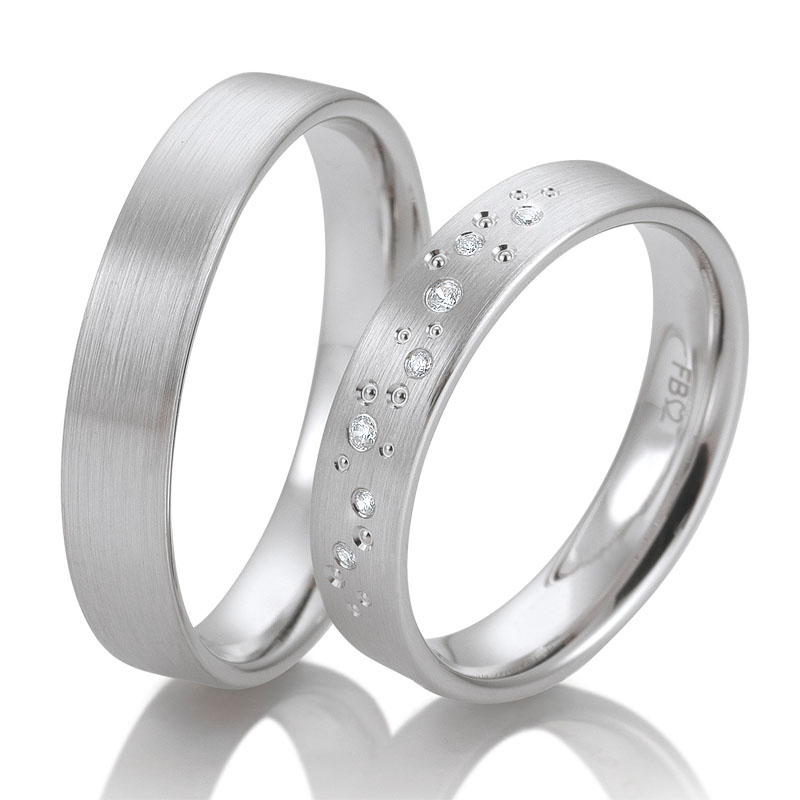  	Aufnahme von matten Trauringen aus Weissgold mit vielen Diamanten als Sternenhimmel und Kreismuste