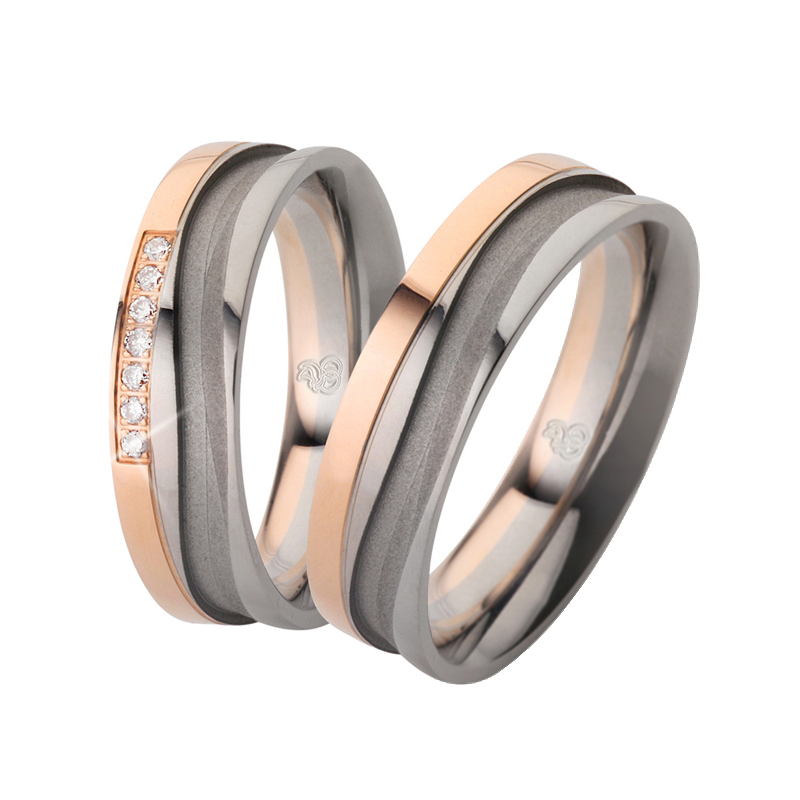 Aufnahme von bicoloren Palladium 500 Roségold Trauringen mit sandmatter Rille und Diamanten 