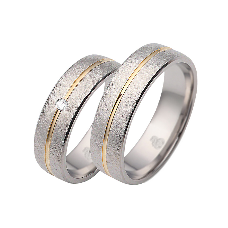 Aufnahme von Trauringen aus Edelstahl&Gelbgold mit Diamanten und strukturierter Oberfläche 