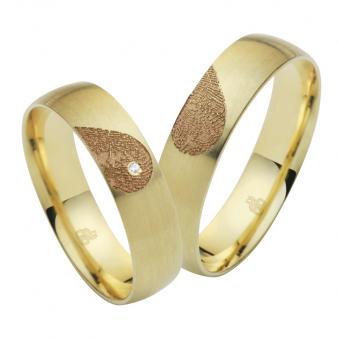 Aufnahme von Eheringen aus Gelbgold mit Diamanten und Herzmuster mit Fingerabdruck