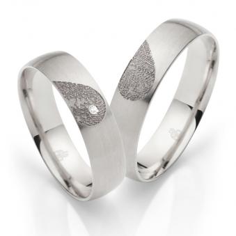 Aufnahme von Eheringen aus Weissgold mit Diamanten und Herzmuster mit Fingerabdruck