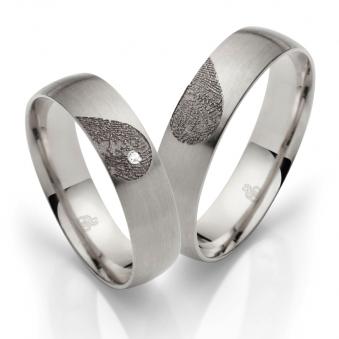 Aufnahme von Eheringen aus Palladium 500 mit Diamanten und Herzmuster mit Fingerabdruck 