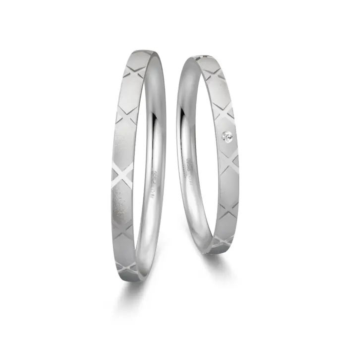 Sandmattierte Eheringe aus Platin mit Muster und Diamanten