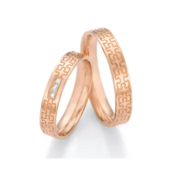 Rotgold Eheringe in Puzzle-Optik mit drei Diamanten in Reihe