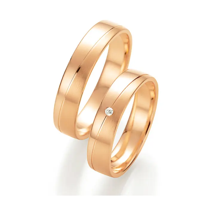 Trauringe aus Roségold mit schräg verlaufender Rille und Diamanten