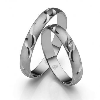 Aufnahme der Eheringe aus mattiertem Palladium 500 mit Schnörkel und Diamanten