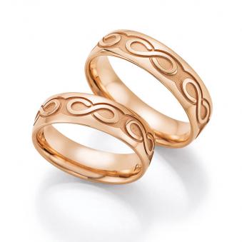 Aufnahme der Traringe aus Roségold mit Unendlichkeit-Zeichen auf mattiem Hintergrund