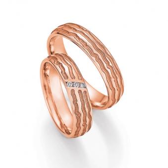 Aufnahme der Eheringe aus Rotgold in Kratzen-Design mit 3 Diamanten