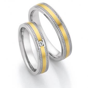 Aufnahme von Eheringen aus Edelstahl & Gelbgold in romatischem Design mit Stein