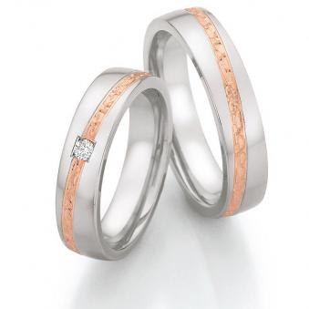 Aufnahme von Trauringen aus Edelstahl mit Roségoldstreifen und Diamanten in viereckiger Fassung