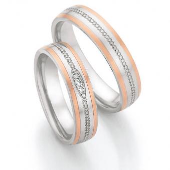 Aufnahme von Eheringen aus Edelstahl mit Roségoldrändern und drei Diamanten