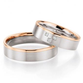 Aufnahme von Palladium 500/Rosègold Trauringen mit drei viereckigen Diamanten