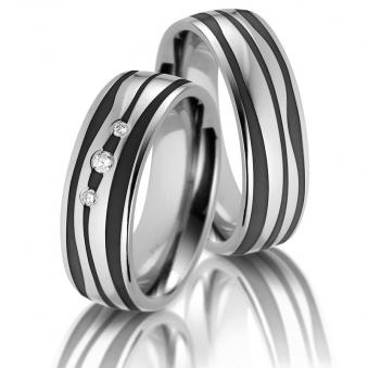 Aufnahme von Trauringen aus Titan und Keramik mit schwarz-weißen Wellen und 3 Diamanten 