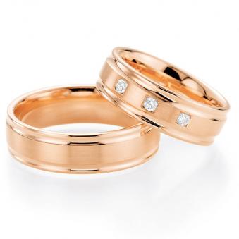 Aufnahme von Rosègold Trauringen mit drei Diamanten in viereckigen Vertiefungen