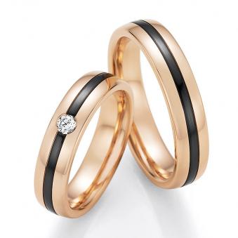Aufnahme von Trauringen aus Roségold mit weißem Diamanten und mittigem Zirconiumstreifen 