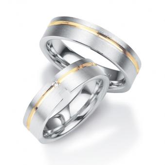 Aufnahme von Trauringen aus platiniertem Silber veredelt mit Gelbgold mit Rillen und Diamanten   