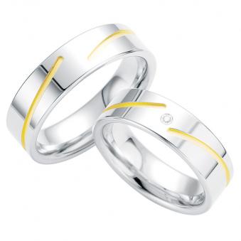 Aufnahme von Trauringen aus Silber mit elegant verlaufender gelbgoldfarbiger Rille und Diamanten
