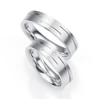 Aufnahme von flachen Eheringen aus platiniertem Silber mit mattiertem Rillenmuster und Diamanten 