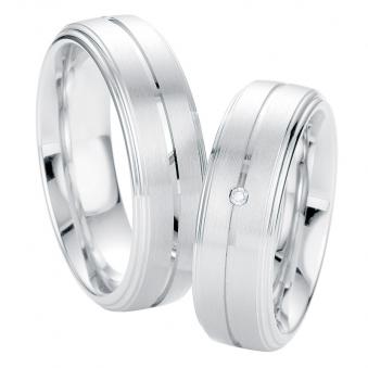  Aufnahme von Trauringen aus platiniertem Silber matt mit polierten Rille und mittigem Diamanten 