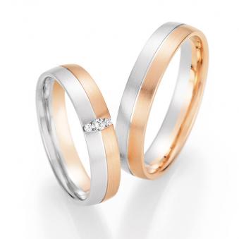 Aufnahme von Trauringen in Rotgold/Weißgold längsmattitert mit drei runden Diamanten