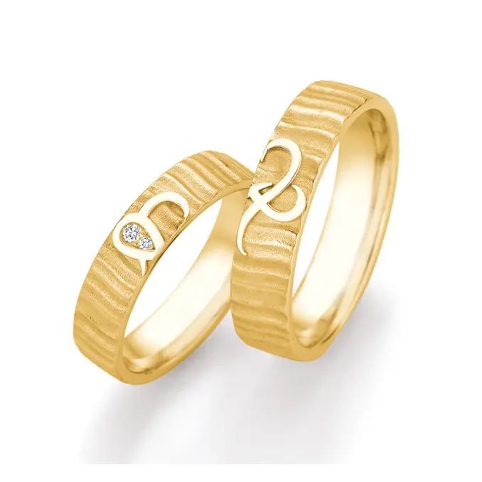 Eheringe aus Gelbgold mit geriffelter Oberfläche und zwei Diamanten mit Unendlichkeitszeichen