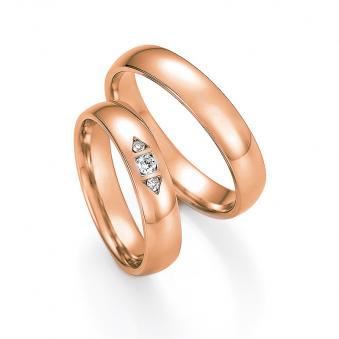 Aufnahme der Trauringe in Rotgold mit 3 Diamanten in pfeilförmig gefassten Vertiefungen