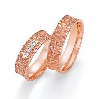 Aufnahme der Trauringe aus Rotgold mit mattem vertieftem Muster und 5 Diamanten