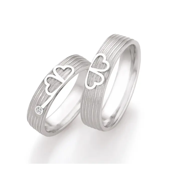 Eheringe aus Weißgold mit einem Kleeblatt als Symbol und Diamant