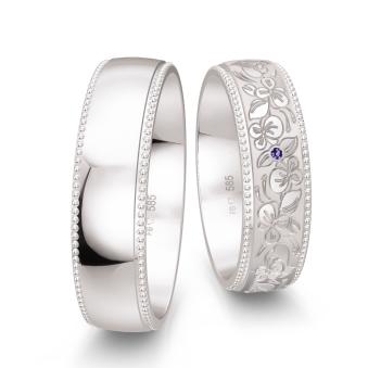 Weißgold Trauringe in Millgriff-Optik verziert mit floralem Muster und violettem Diamanten 