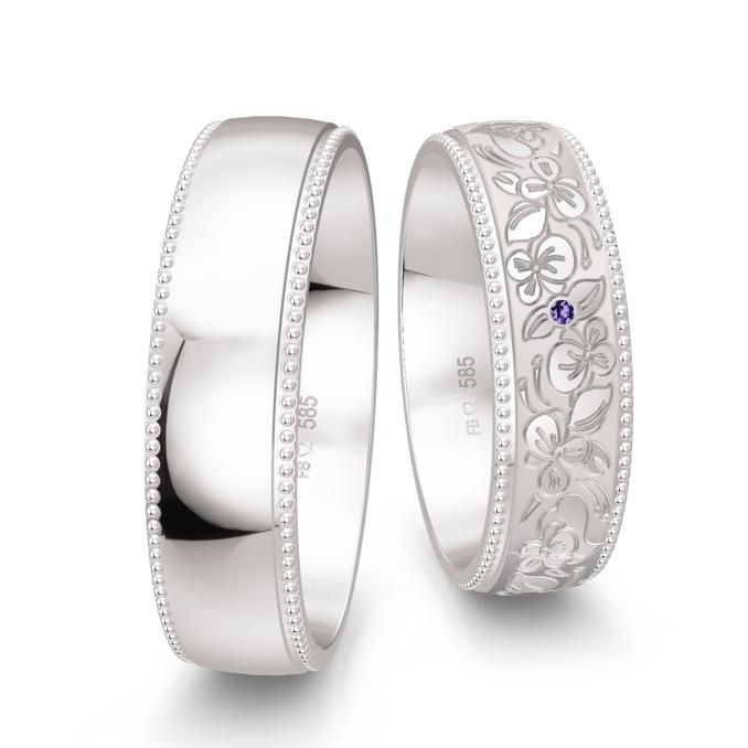 Weißgold Trauringe in Millgriff-Optik verziert mit floralem Muster und violettem Diamanten