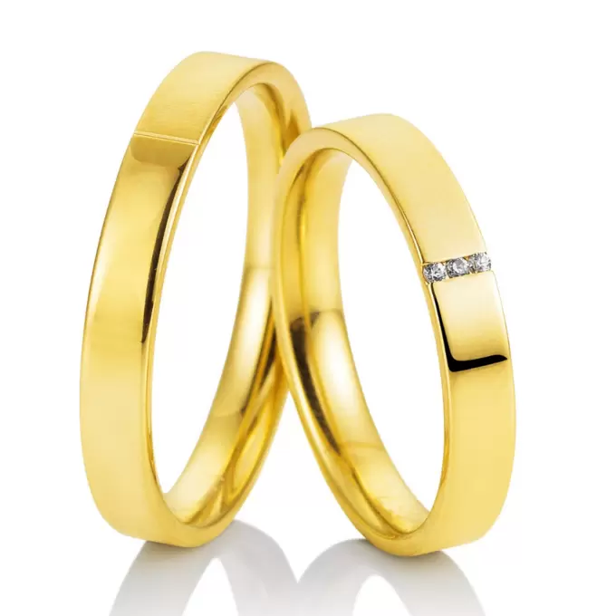 Halbmatte und halbpolierte Eheringe aus Gelbgold mit 3 kanalgefassten Diamanten