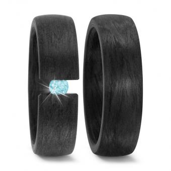 Aufnahme von schwarzen gemaserten Carbon Eheringen mit eingespanntem blauen Diamanten 