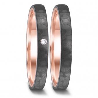 Aufnahme von schmalen Eheringen aus schwarzem Carbon mit Rotgold und Diamanten