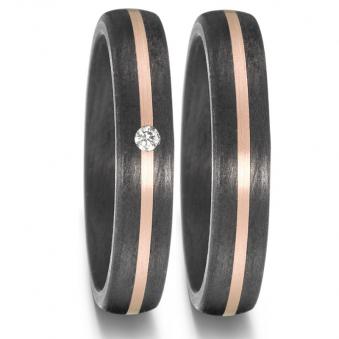 Aufnahme von schmal designten Trauringen aus Carbon mit Rosègoldstreifen und weißem Diamanten