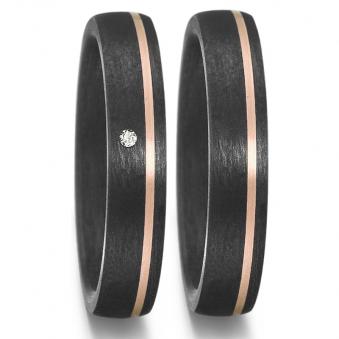 Aufnahme von Trauringen aus Carbon mit schmalem Roségoldstreifen und weißem Diamanten